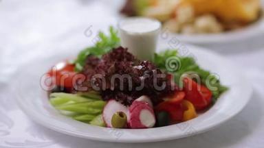装饰精美的新鲜沙拉。 场景。 在餐厅用蔬菜沙拉装饰精美的盘子